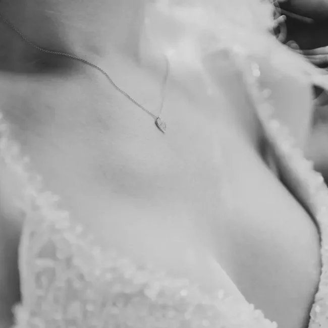 Detailaufnahme von Brautkleid und Halskette bei der Hochzeit.