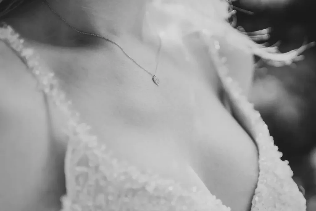Detailaufnahme von Brautkleid und Halskette bei der Hochzeit.