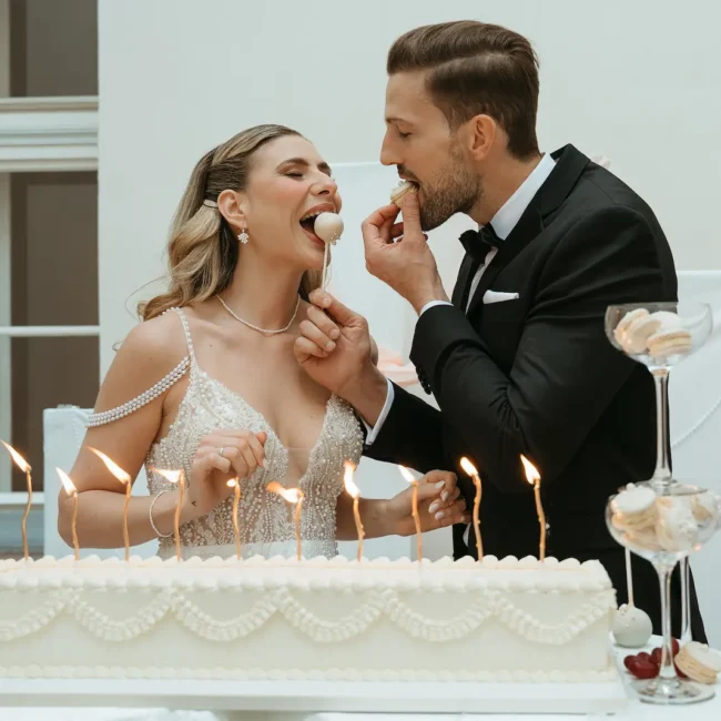 Braut und Bräutigam probieren gemeinsam ihre Hochzeitstorte