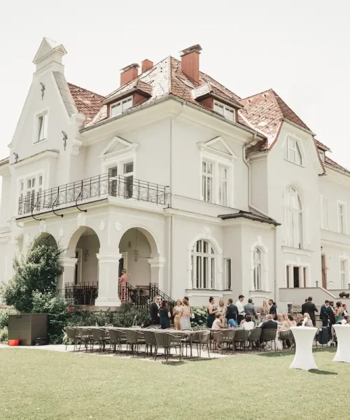 Elegante Villa als Hochzeitslocation mit Gästen im Garten